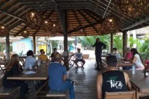 Pessoas sentadas em frente a um homem de pé.