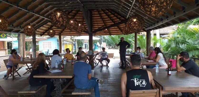 Pessoas sentadas em frente a um homem de pé.