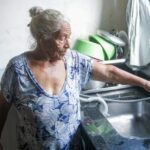 Dona Maria, de 77 anos, mora há 16 anos no bairro. Ela conta que quando chegou, não havia sequer energia elétrica. Agora, ela está esperançosa para a chegada de água tratada à região. Foto: Rafael Pinheiro/JB Litoral