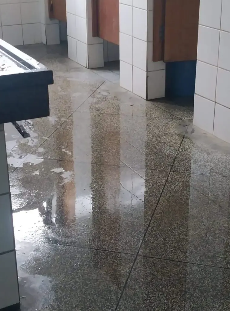 Chão do banheiro masculino completamente alagado