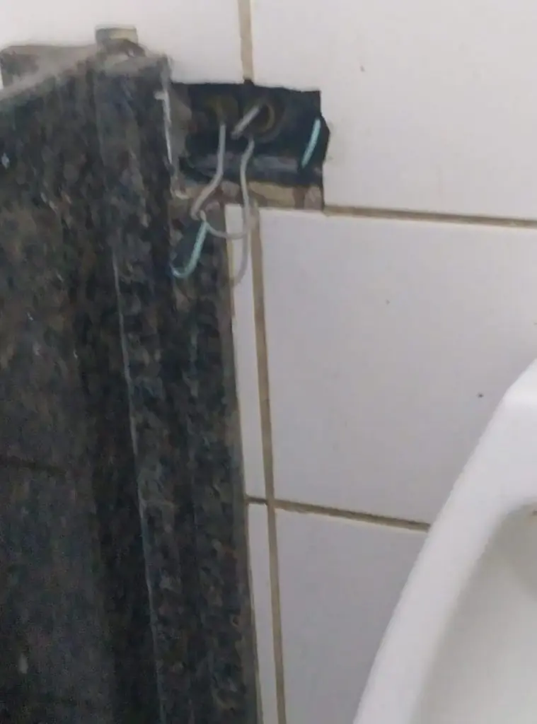 Fio elétrico expostos em cima da pia e mictório.