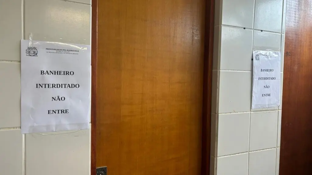 Banheiro feminino da rodoviária de Paranaguá interditado e em estado precário, com vasos sanitários sujos de fezes e sem água para uso.