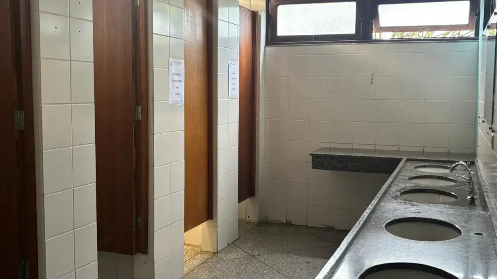 Banheiro feminino da rodoviária de Paranaguá interditado e em estado precário, com vasos sanitários sujos de fezes e sem água para uso.